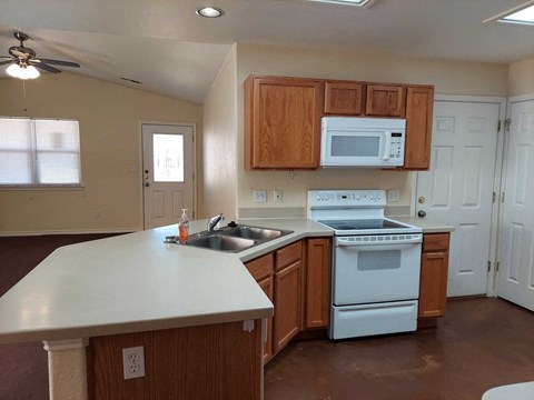A kitchen with brown cabinets and white appliances.