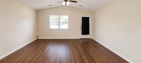 Empty room with wood flooring and a ceiling fan.