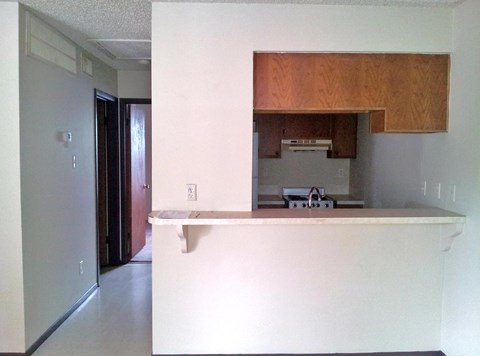 A kitchen with a white counter top and a refrigerator.