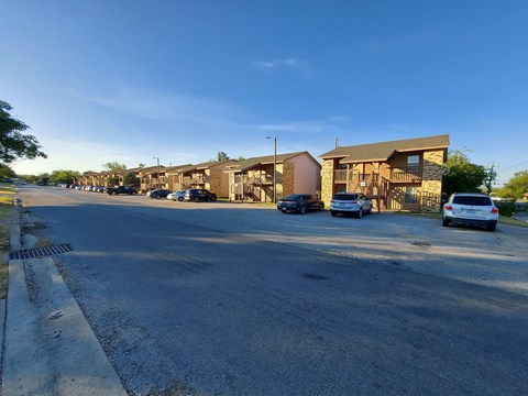 A street view of a residential area with houses and cars.