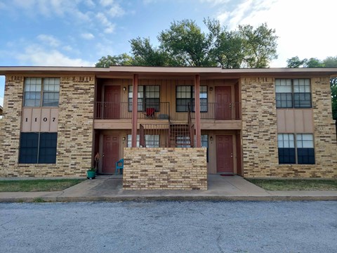 A stone building with a red door and windows.