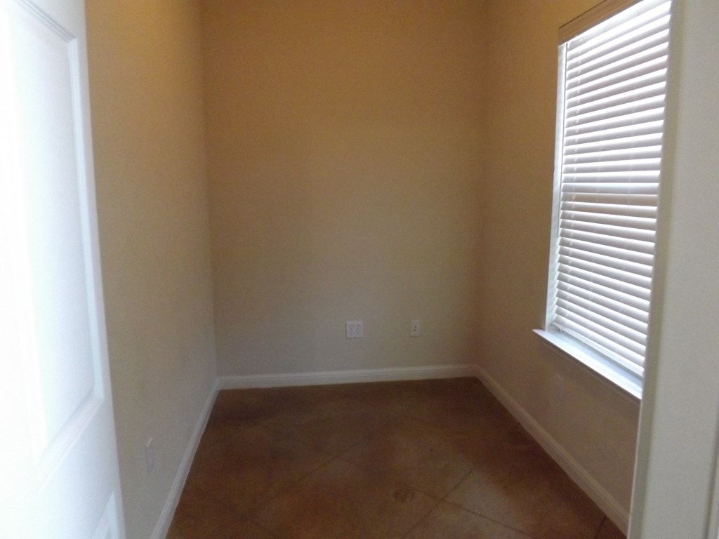 an empty room with two windows and a tiled floor