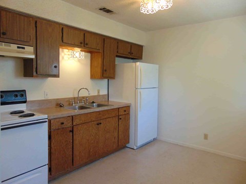 a kitchen with white appliances and wooden cabinets