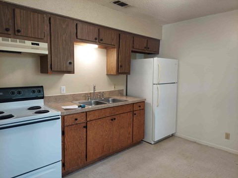 A kitchen with a white stove and a white refrigerator.