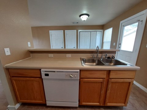 A kitchen with a white dishwasher and a sink.