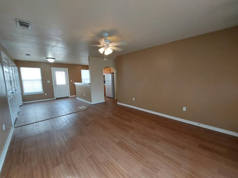 A room with a ceiling fan and wooden flooring.