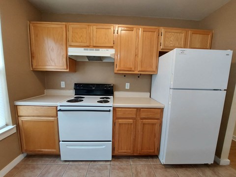 A kitchen with wooden cabinets and a white refrigerator.
