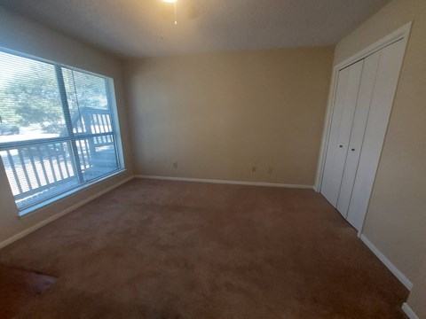 Empty room with brown carpet and a white closet.