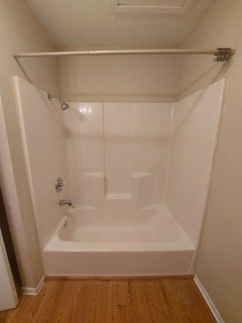 A white bathroom with a tub and shower.