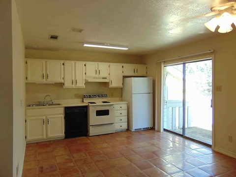a kitchen with white appliances and a sliding glass door