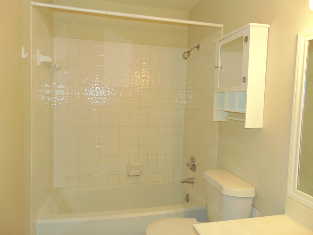 a white bathroom with a tub and a toilet