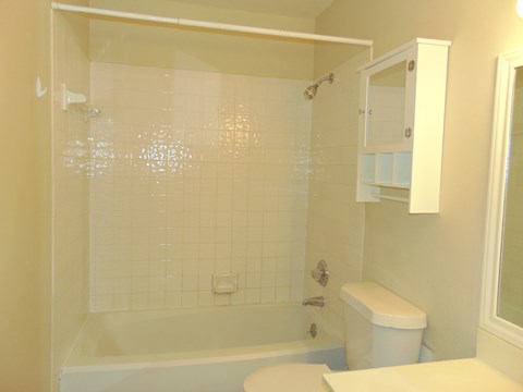a white bathroom with a tub and a toilet