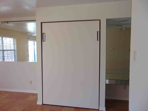 an empty room with a white wall and a sliding door