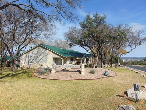 a house with a green roof on the side of a road