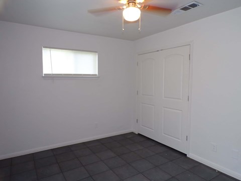 A room with a ceiling fan and a window.