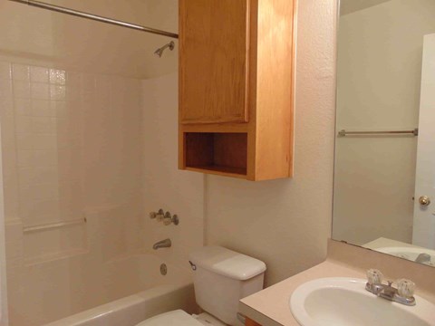 A white bathroom with a toilet, sink, and shower.