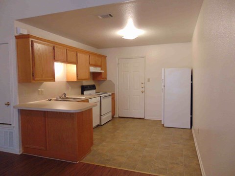 A kitchen with wooden cabinets and a white dishwasher.
