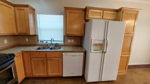 A kitchen with wooden cabinets and a white refrigerator.