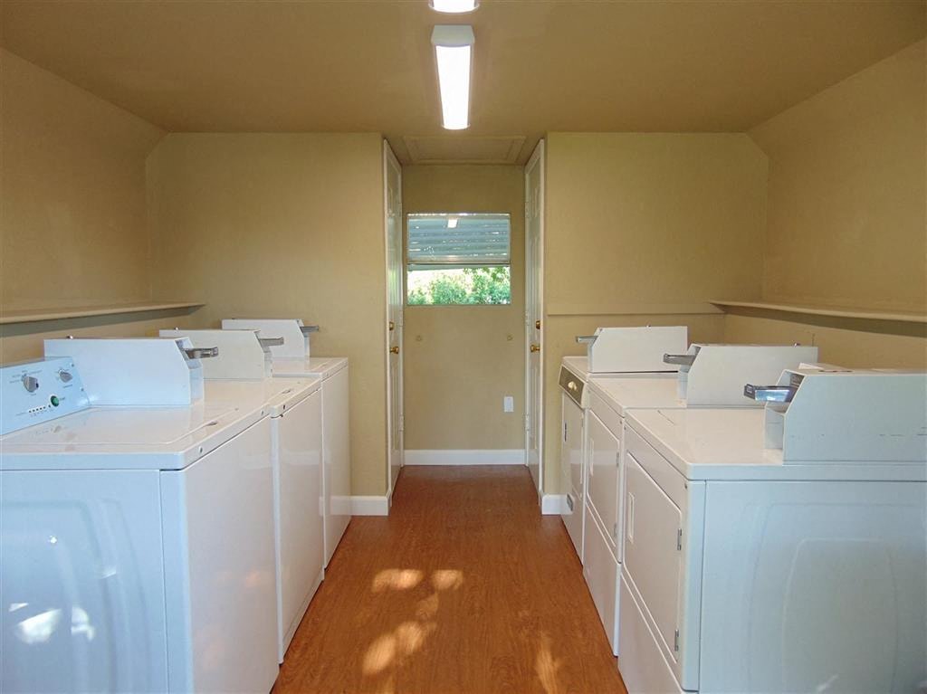 an empty laundry room with white washers and dryers