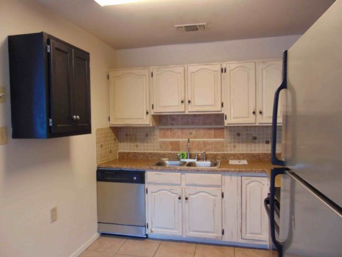 A kitchen with white cabinets and a black cabinet.
