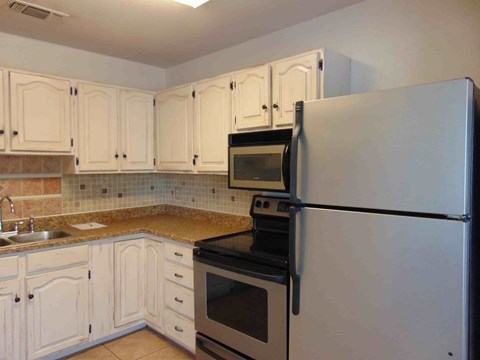 A kitchen with white cabinets and a black stove top oven.
