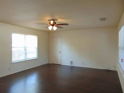 A room with a ceiling fan and a door.
