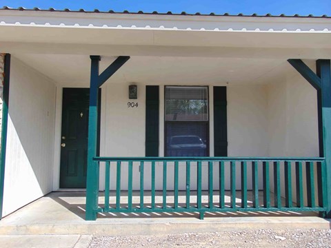 A house with a green door and a green railing.
