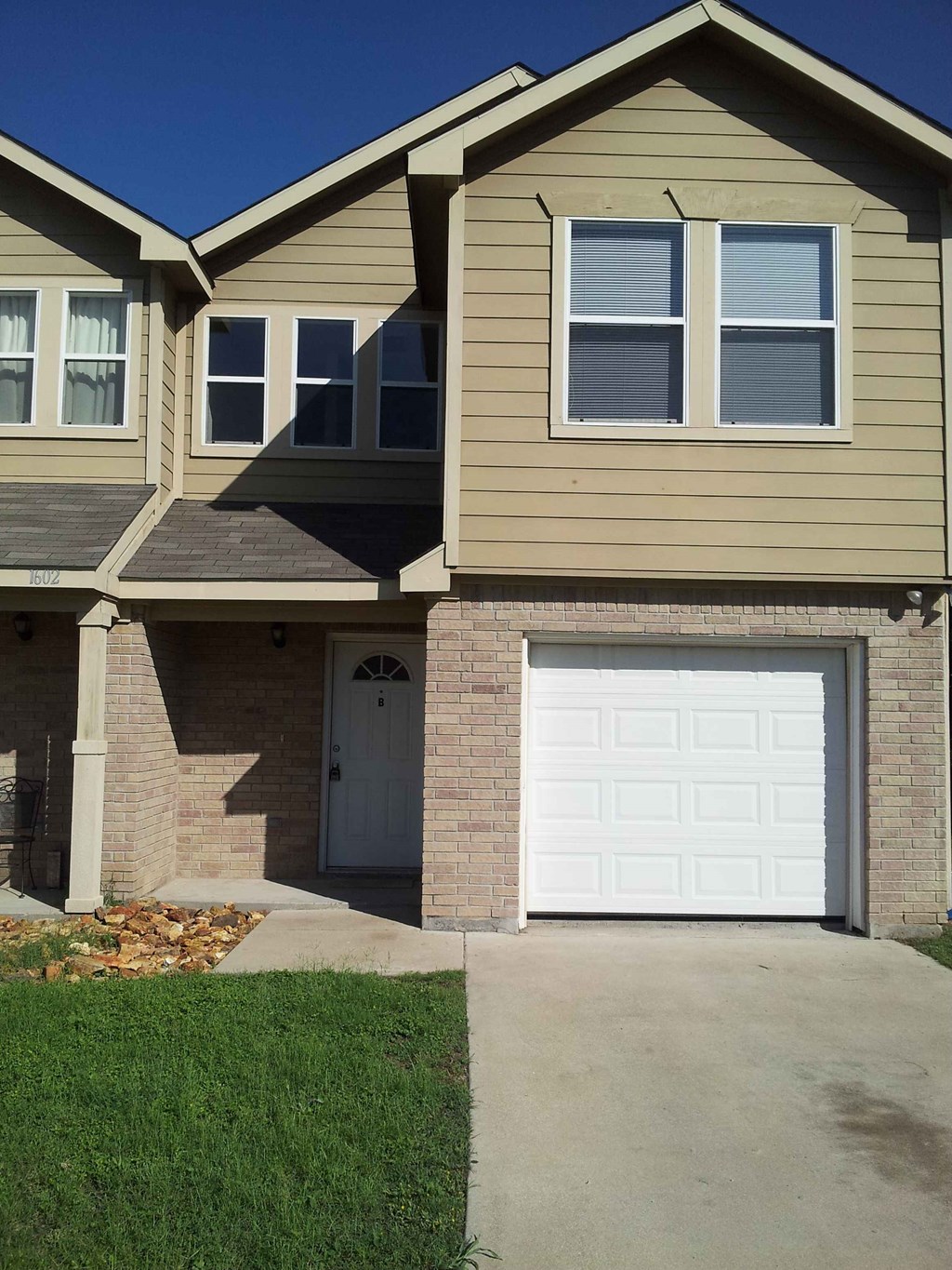 a tan house with a white garage door