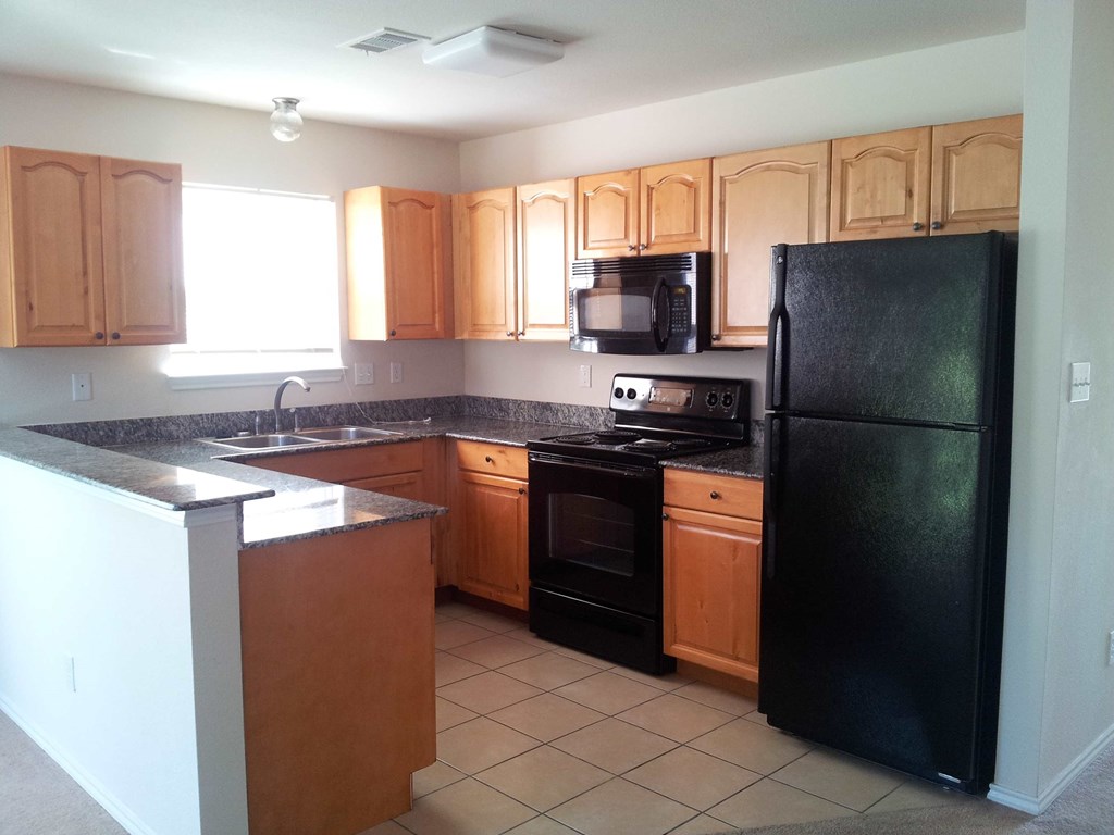a kitchen with black appliances and wooden cabinets
