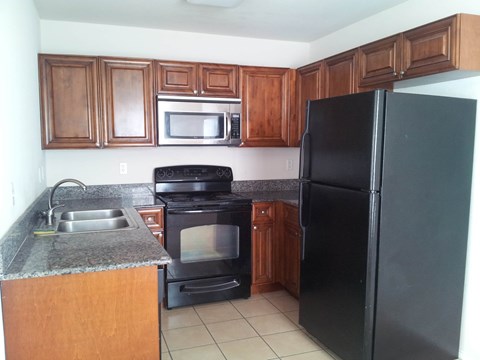 a kitchen with black appliances and wooden cabinets