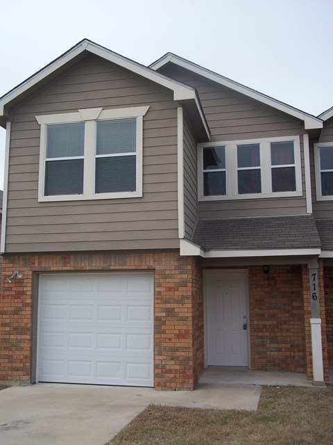 A house with a grey roof and a white garage door.