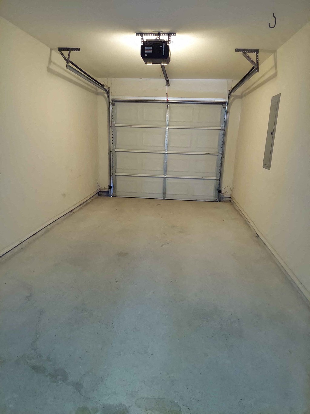 a empty garage with white walls and a tv on the ceiling