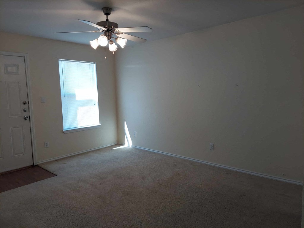 a living room with a ceiling fan and a window