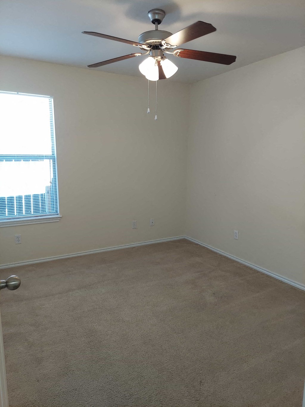 a empty room with a ceiling fan and a window