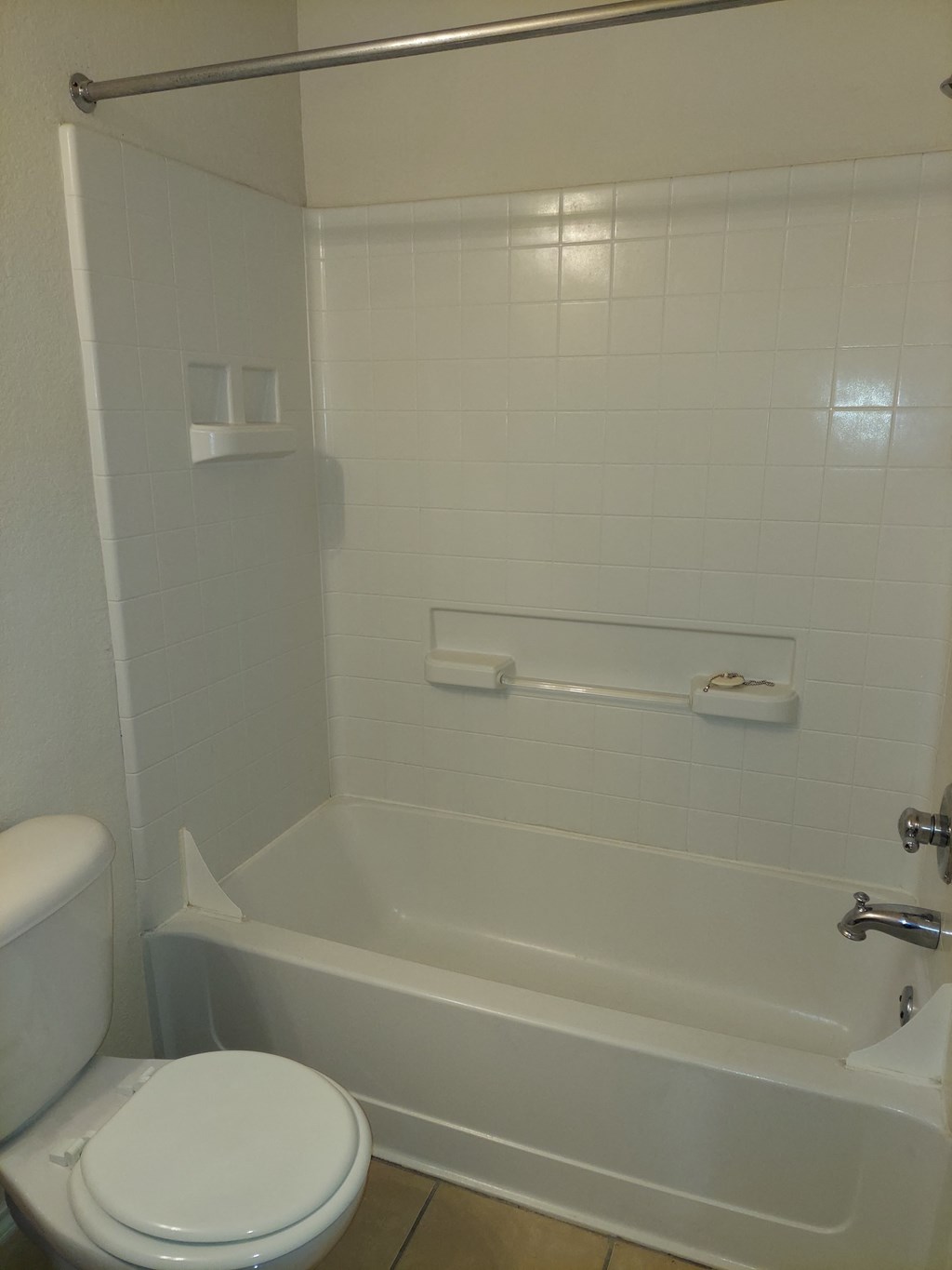 a white bathroom with a toilet and a tub