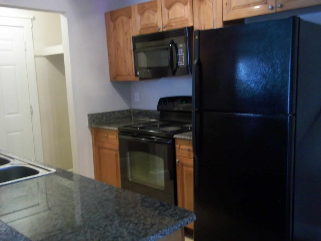 a kitchen with black appliances and granite counter tops