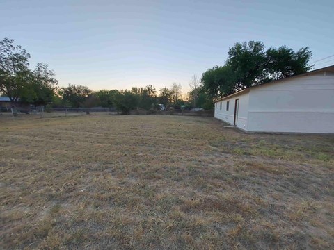 A field with a building on the right side.
