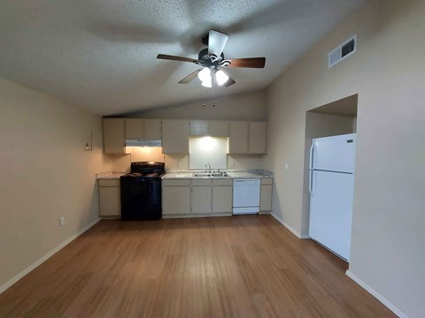 A kitchen with a refrigerator, dishwasher, and oven.