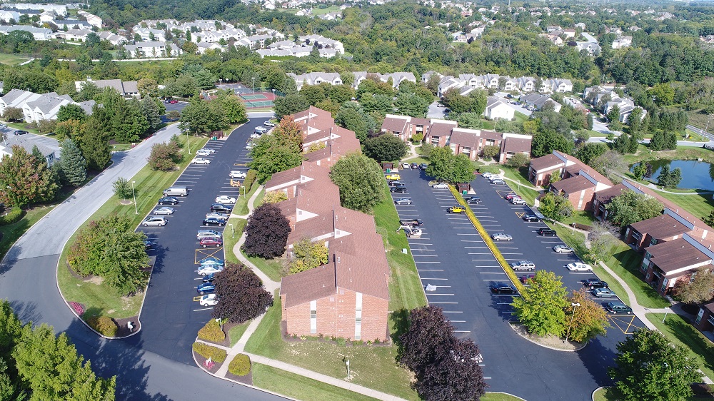 an aerial view of a neighborhood with cars parked in a parking lot