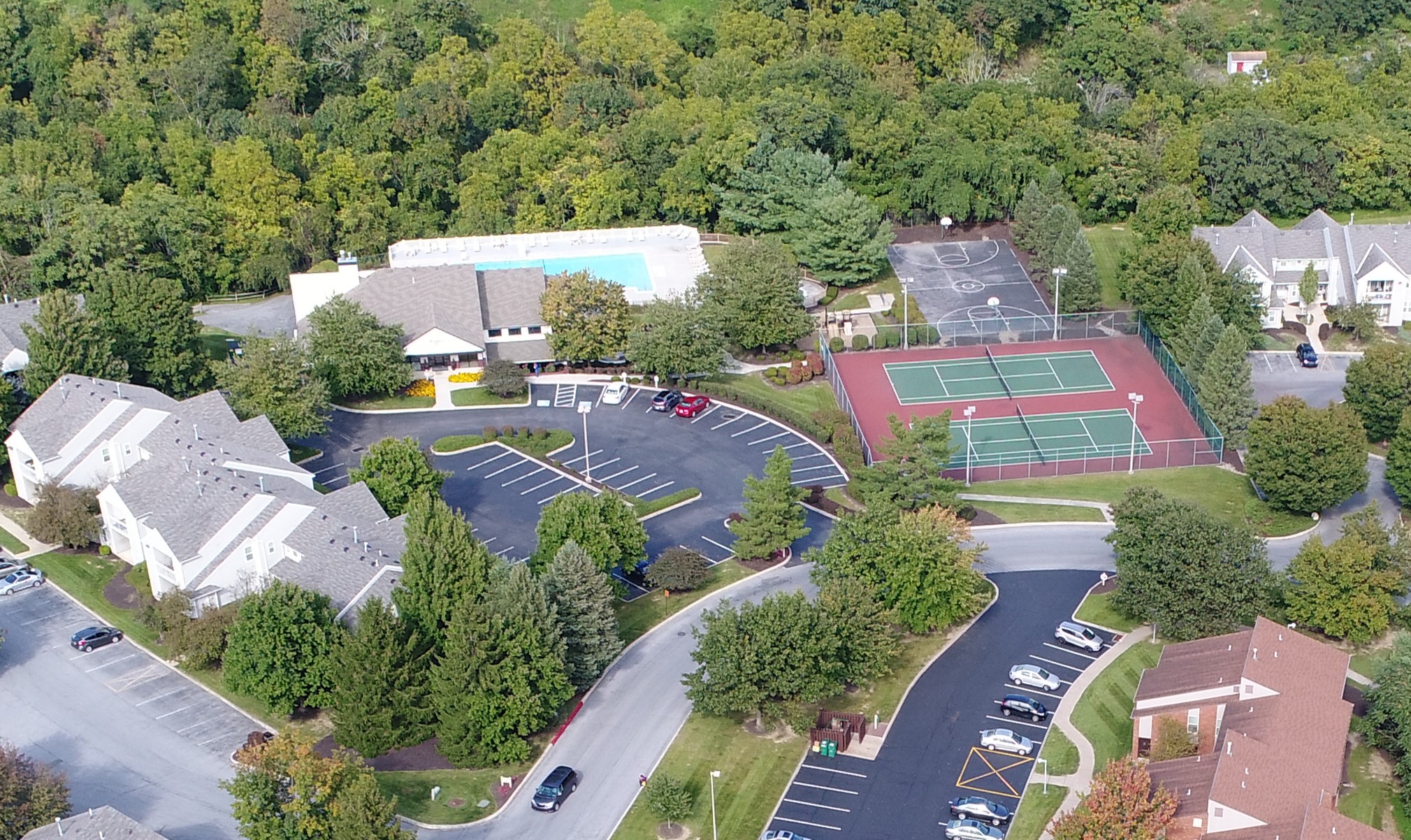an aerial view of a neighborhood with a tennis court and a parking lot