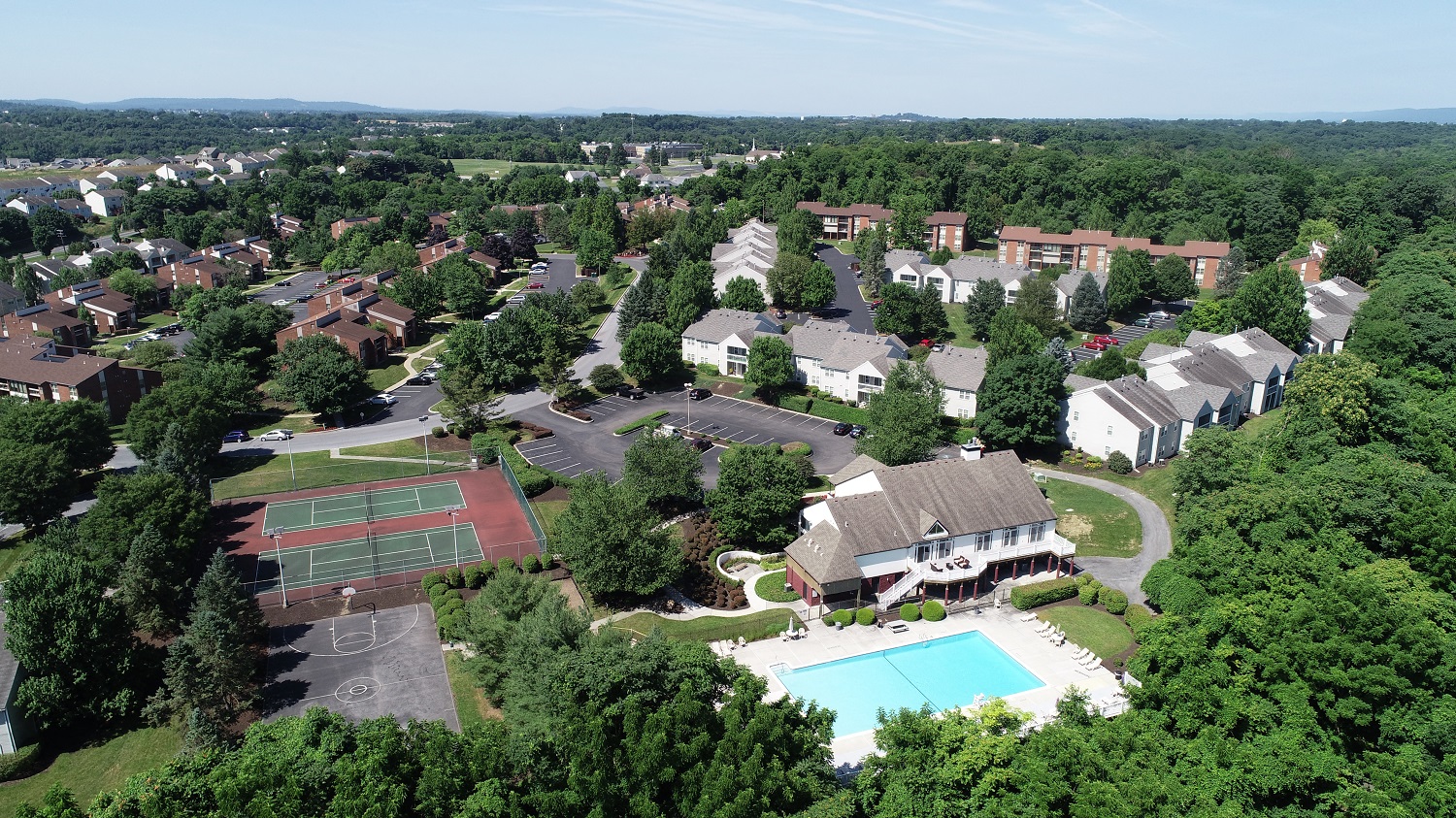 an aerial view of a neighborhood with a swimming pool and tennis court