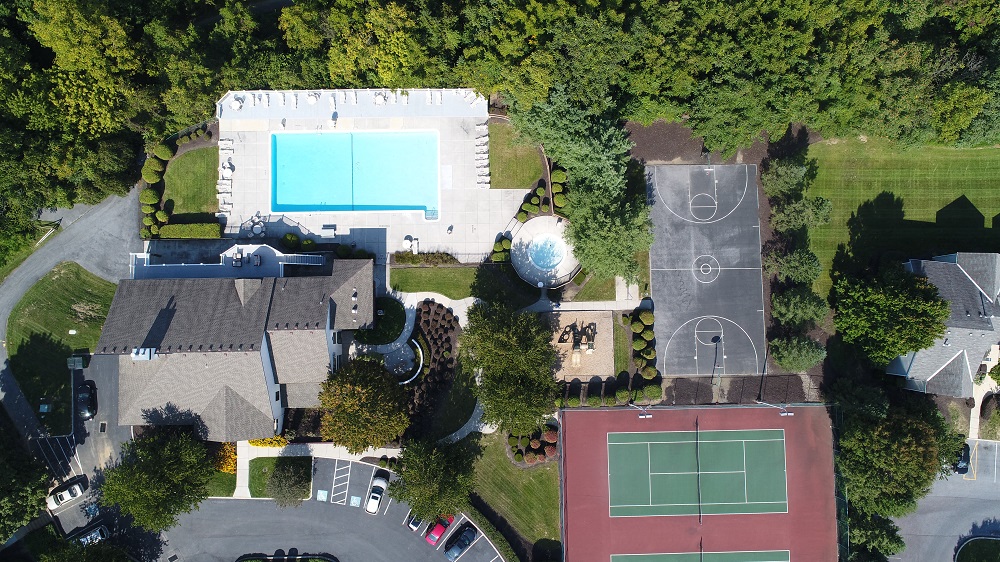 arial view of a house with a tennis court and a pool