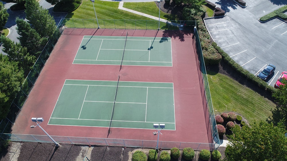 an aerial view of a tennis court on a red court