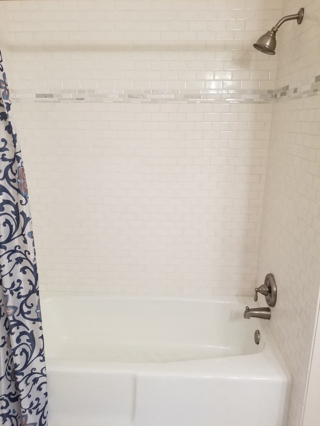a white bath tub in a bathroom with white subway tile