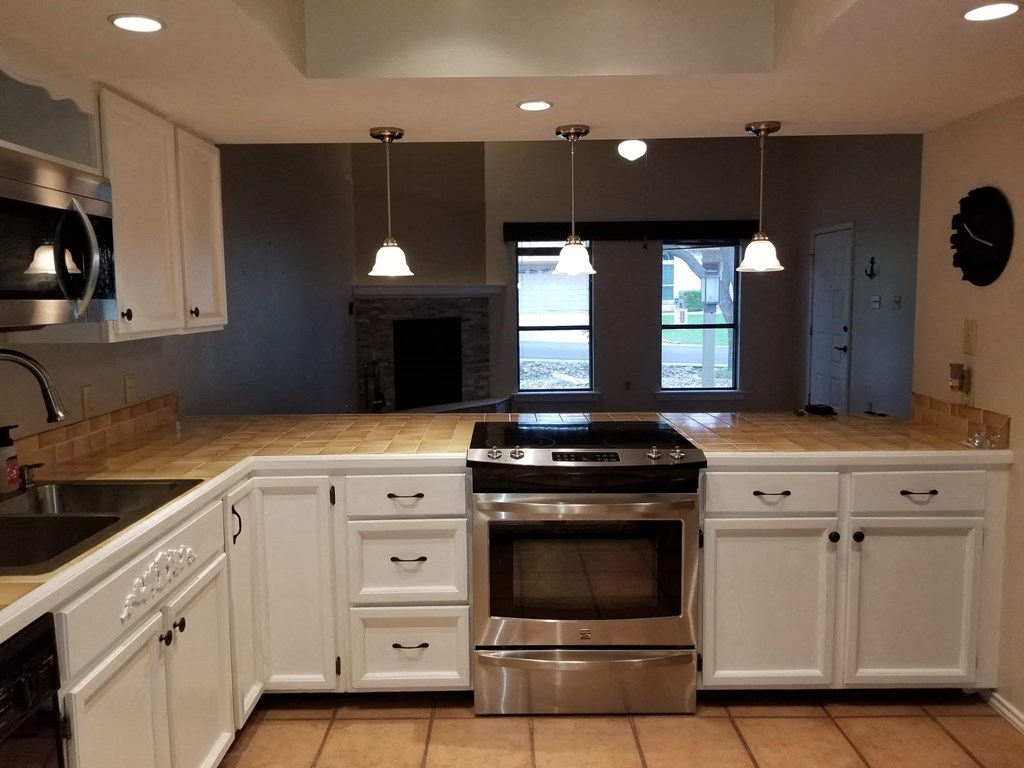 a kitchen with white cabinets and stainless steel appliances