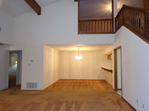 A room with wooden floors and a staircase.