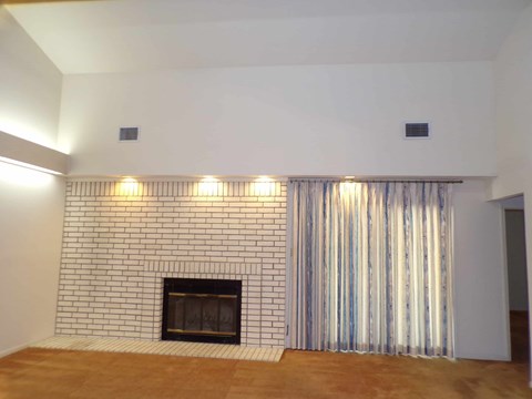 A fireplace with a striped curtain on the side.