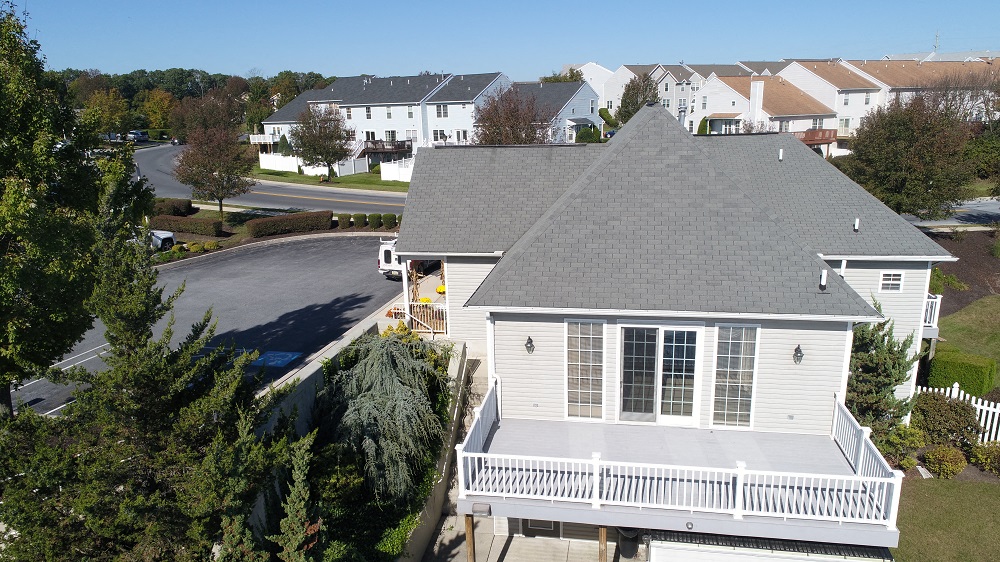 a white house with a gray roof and a white porch