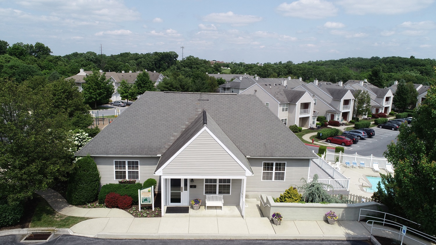 an aerial view of a white house with a parking lot