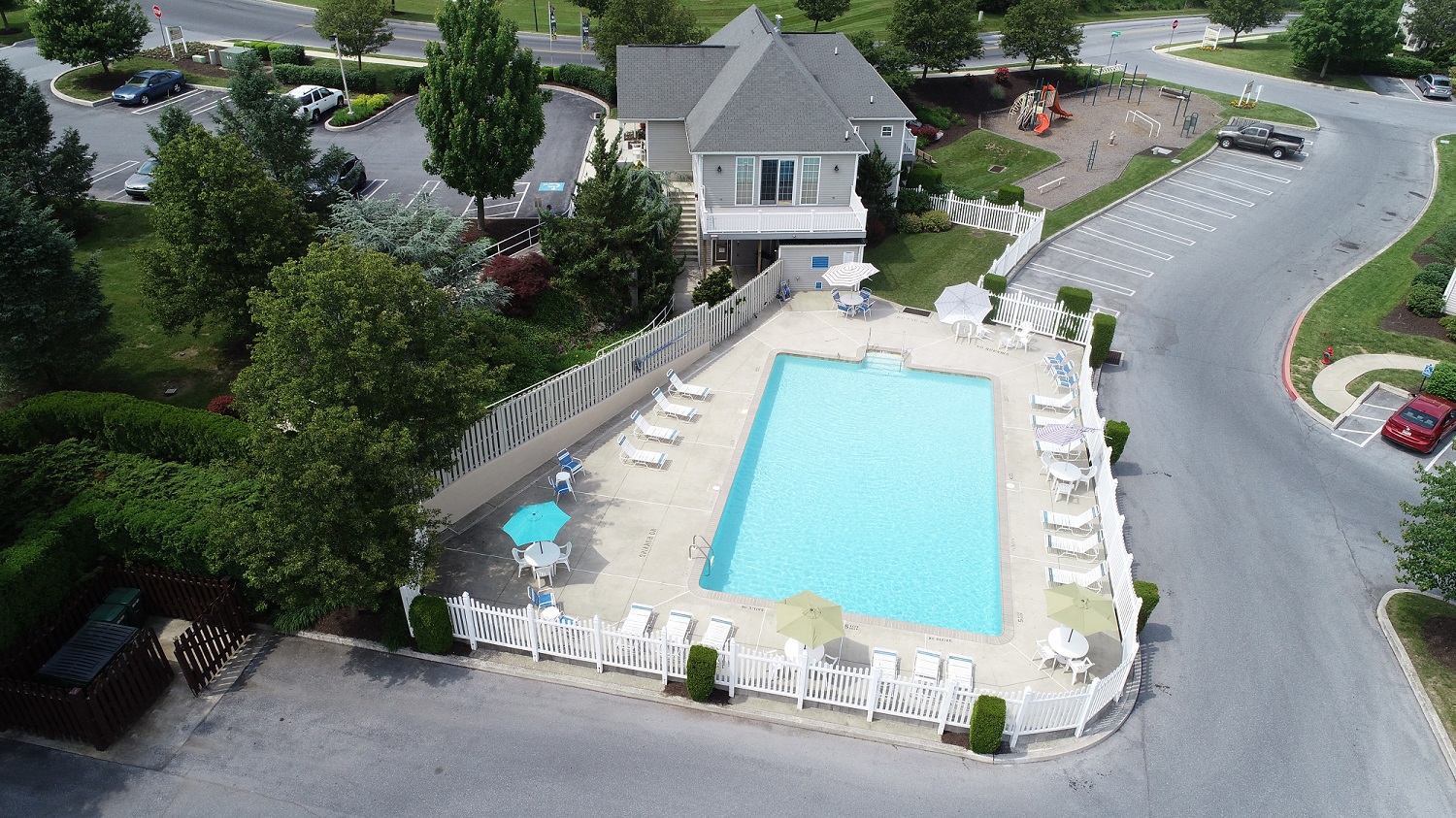 an aerial view of a swimming pool in front of a house